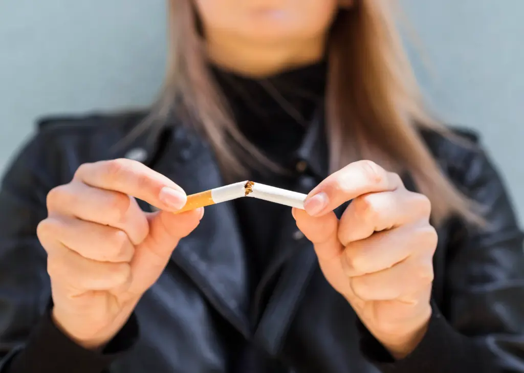 Chica partiendo un cigarrillo