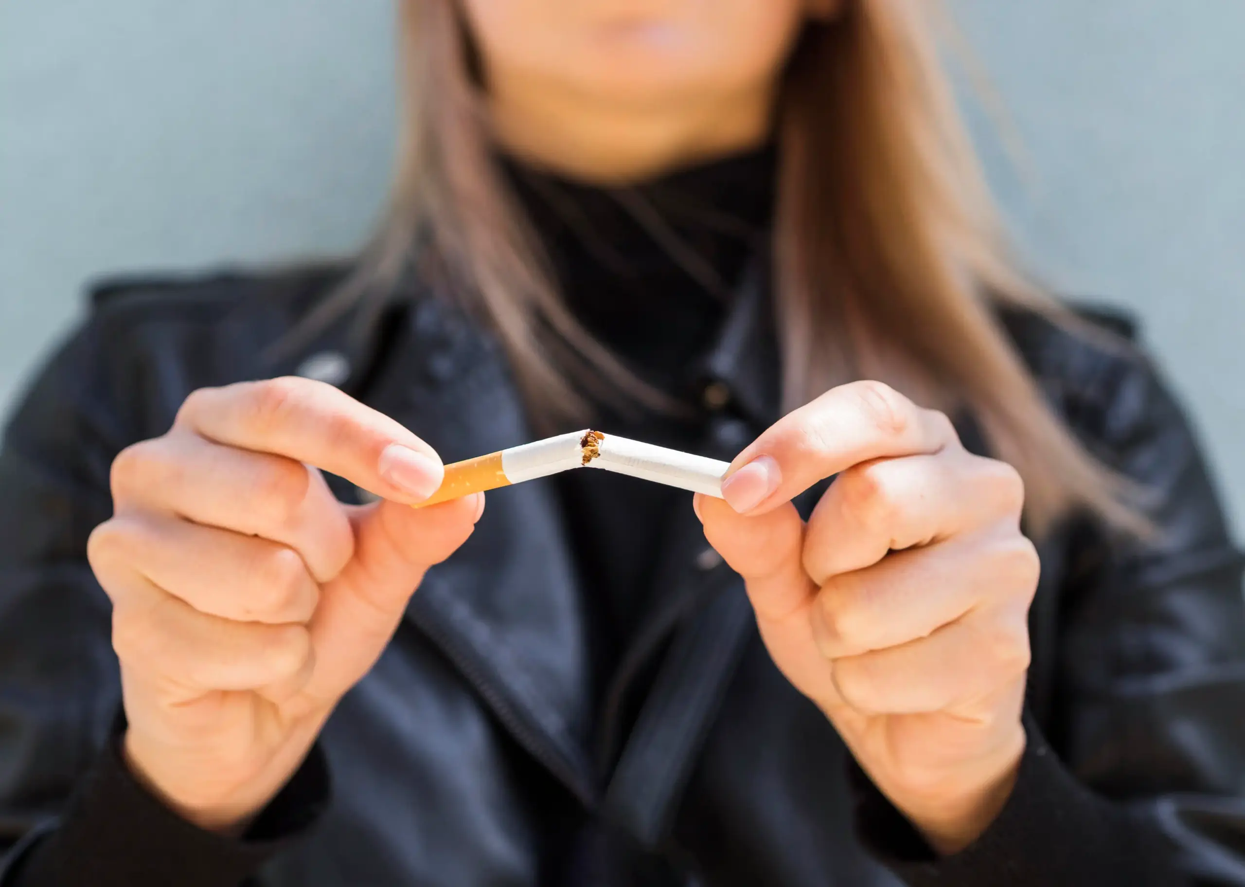 Chica partiendo un cigarrillo