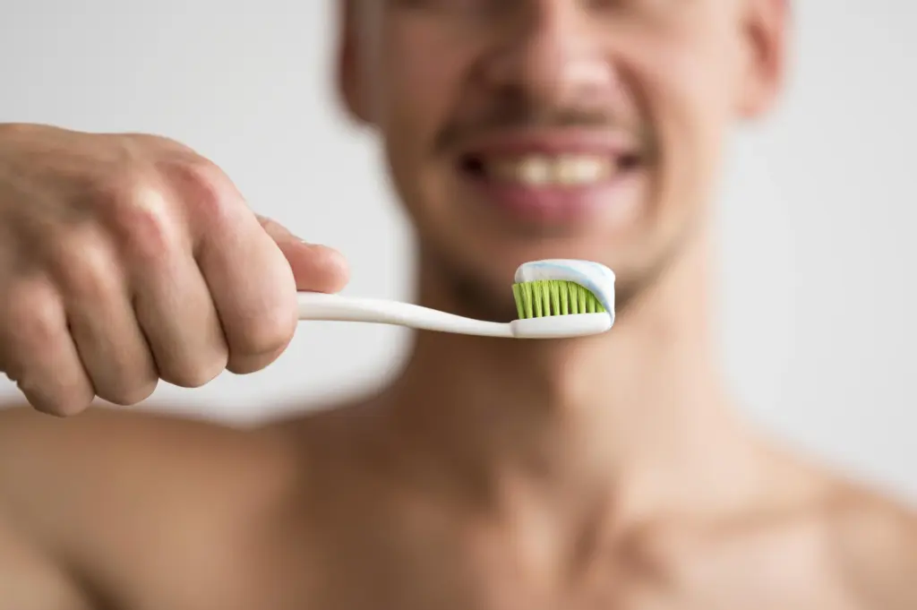 Hombre sosteniendo un cepillo de dientes
